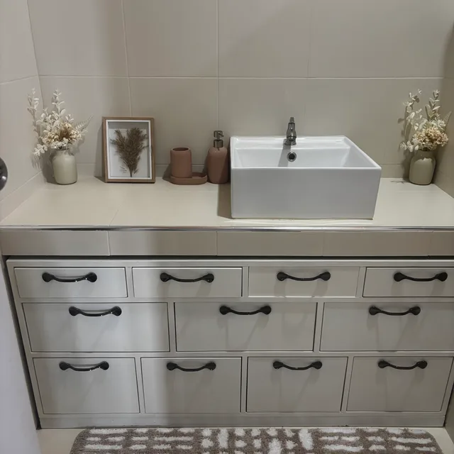 White vanity unit with vessel basin, dried flowers and framed print