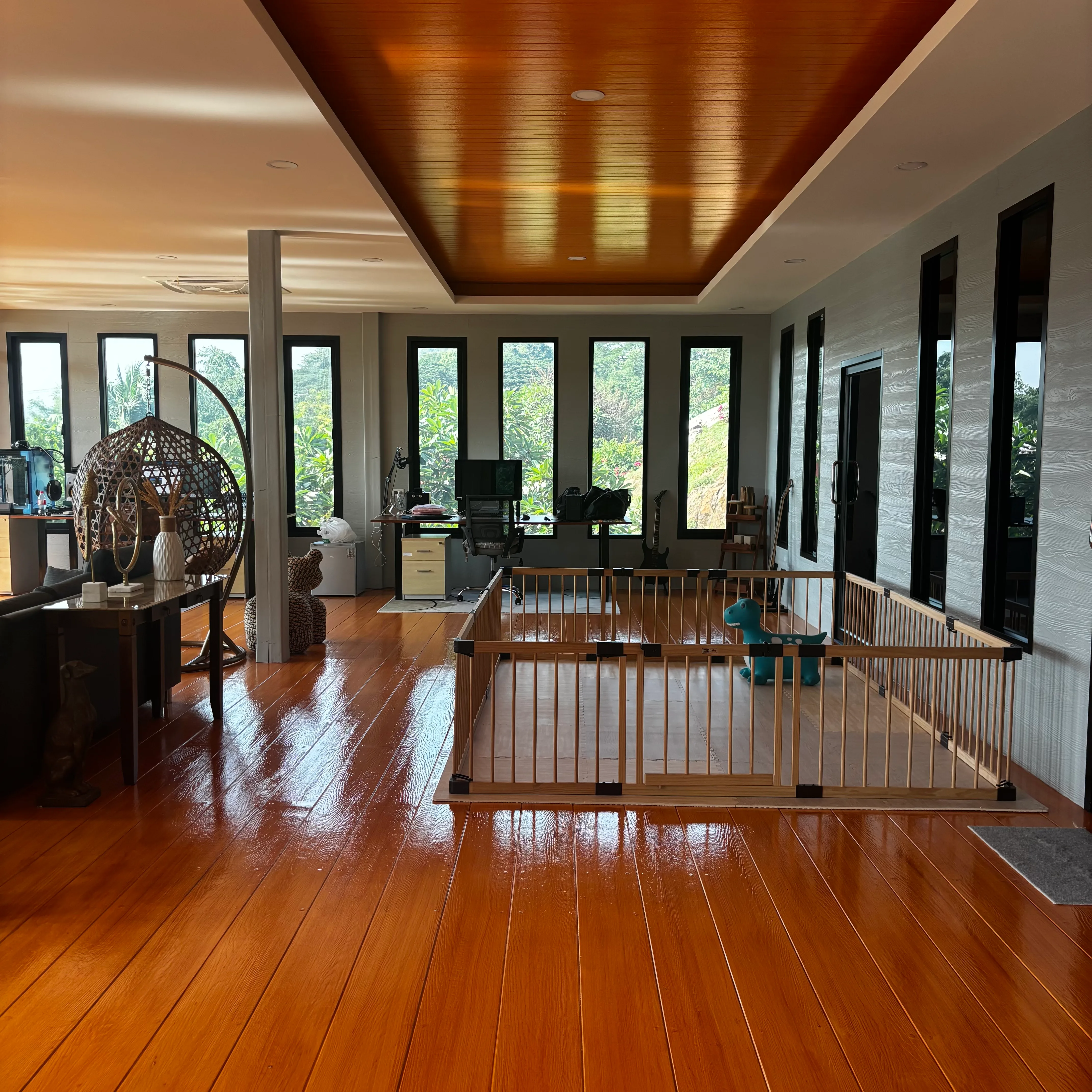 Wide open-plan interior with wooden recessed ceiling, hardwood floors and rows of windows