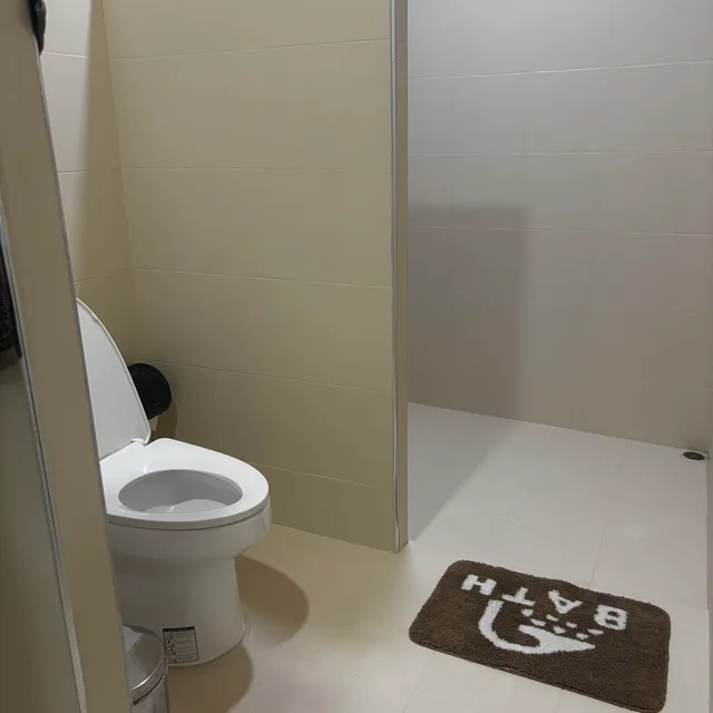Spacious bathroom with walk-in shower area and bath mat
